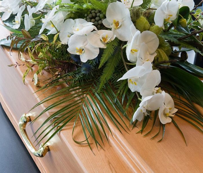 Weiße Blumen auf Holzsarg