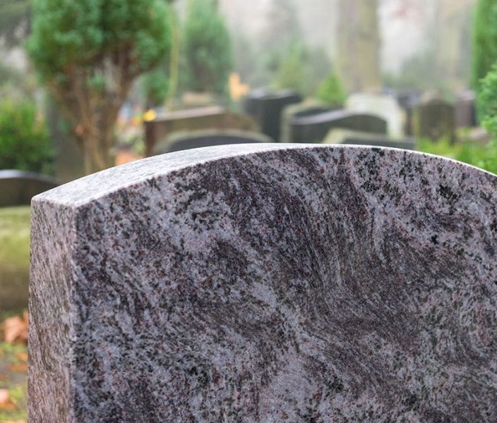 Friedhof mit Grabstein im Vordergrund
